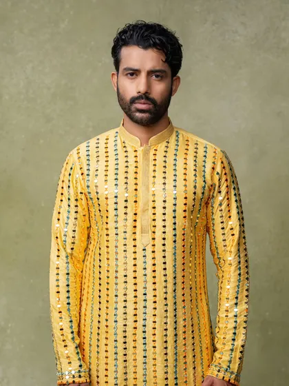 A straightforward portrait of a male model in a yellow mirror-work kurta. This type of clean, well-lit shot is the backbone of any successful e-commerce store.