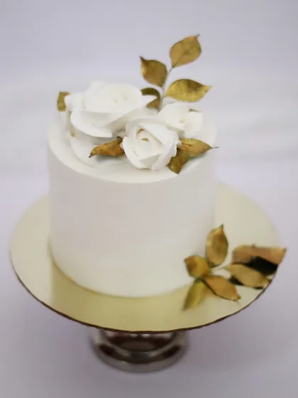 Sometimes, simple is the most elegant. This minimalist cake with its clean white frosting, delicate sugar flowers, and touches of gold is perfect for a sophisticated anniversary, engagement, or even a small wedding.