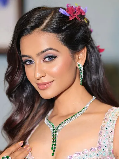 A confident and engaging shot of the bride. The makeup is designed to be picture-perfect, with a focus on luminous skin and eyes that sparkle.