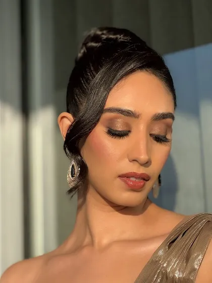 This shot showcases the elegant updo and the soft, blended makeup from a different angle. The focus is on creating a look that is both bold and effortlessly chic.
