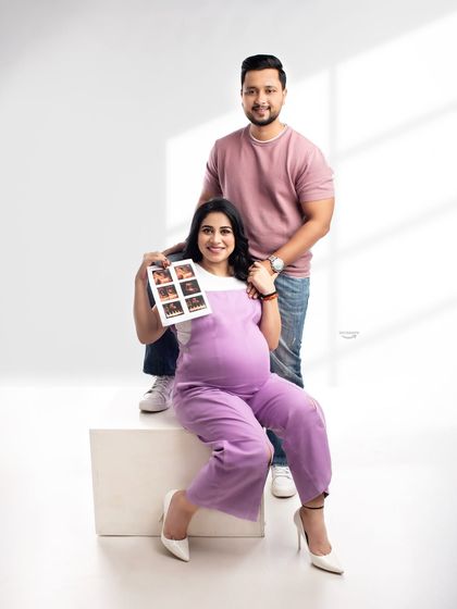 A proud mom-to-be shows off her sonogram pictures in this happy couple portrait. It's a wonderful way to include the very first pictures of the baby in the maternity shoot.