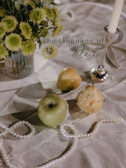 A detail of the tablescape, with fresh fruit and pearls creating a beautiful still life. The text overlay reads "the language of detail".