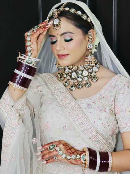 A graceful pose, highlighting the intricate details of her white lehenga and jewellery.