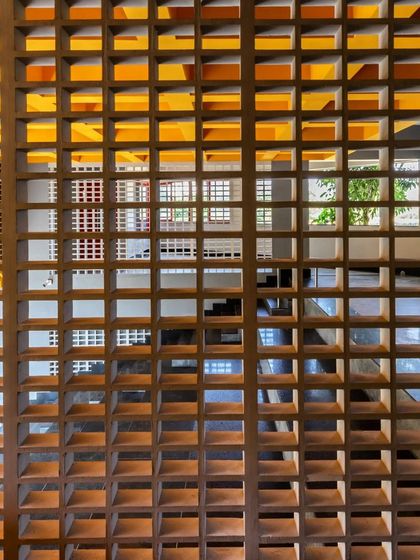A close-up of the terracotta jaali screen at L'Atelier, which filters light and provides privacy while maintaining a sense of openness.