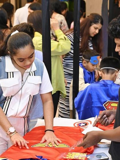 A young guest gets creative at the superhero cape-making station. Providing hands-on activities like this ensures all the kids feel involved and get to take home a personalized party favor.