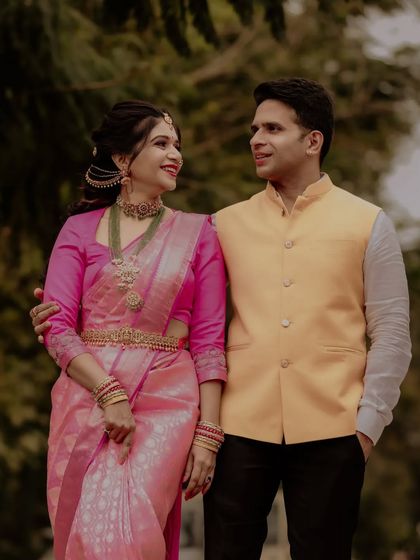 A couple shares a laugh in their elegant traditional attire, a perfect candid moment from their pre-wedding shoot.