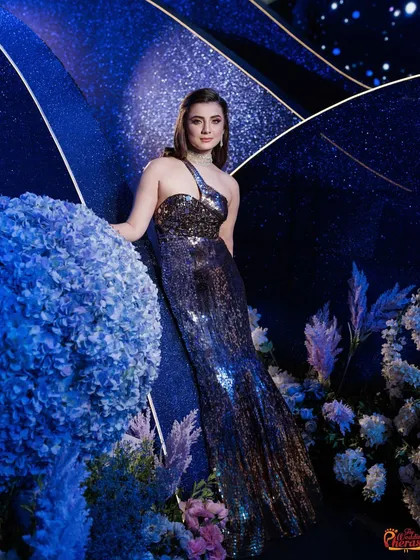 The decor serves as the perfect backdrop for the stars of the evening. Here, the bride is captured against the glittering, deep blue textures and floral arrangements of the cosmic landscape I designed.