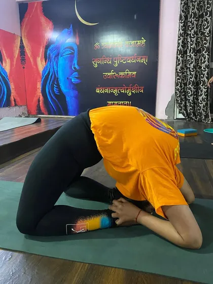 Another student works on the same advanced Kapotasana posture. Seeing peers achieve these poses inspires the entire class to continue their dedicated practice.