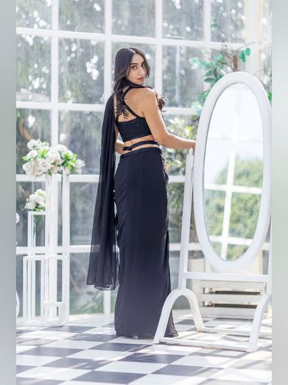 The back view of this chic black draped saree, showcasing the stylish blouse and modern silhouette.