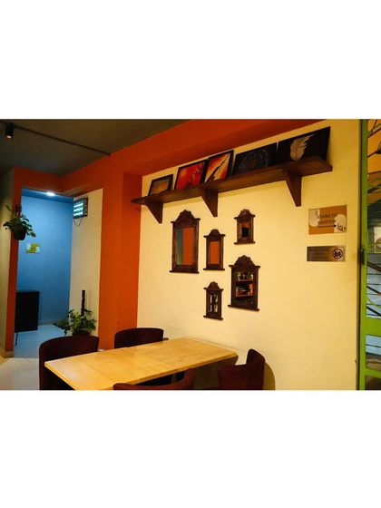 A quiet corner perfect for a small group or a date. The wall is decorated with antique-style mirrors, adding a touch of vintage charm to the modern space.