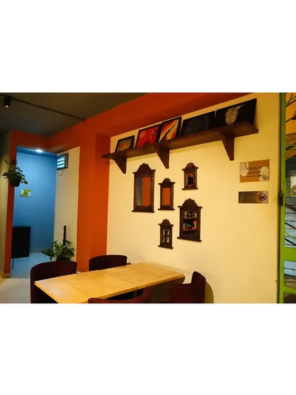 A quiet corner perfect for a small group or a date. The wall is decorated with antique-style mirrors, adding a touch of vintage charm to the modern space.