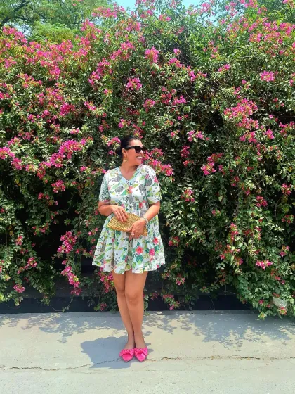 The same floral mini dress, styled with a woven clutch. It's a simple, fresh look for exploring a new city or resort.