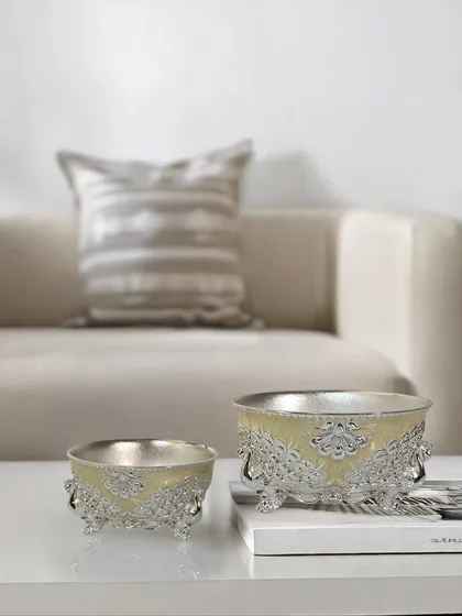 A touch of artistry, a hint of shine. My enamel bowl with engraved peacock stands, featured in a delicate buttercup yellow, is a keepsake you will cherish. Perfect for festive gifting.