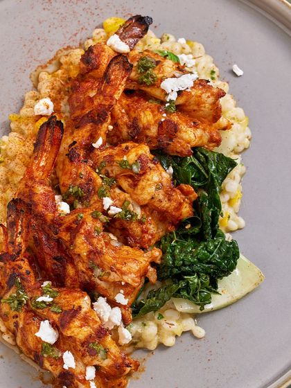 A top-down view of the Smoked Chili Grilled Prawns, showing the vibrant colors of the dish and the creamy texture of the barley risotto.