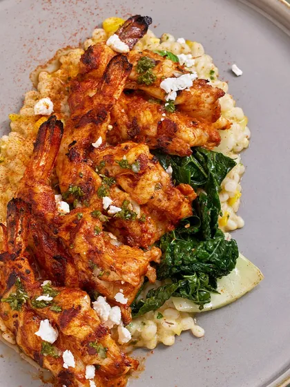 A top-down view of the Smoked Chili Grilled Prawns, showing the vibrant colors of the dish and the creamy texture of the barley risotto.