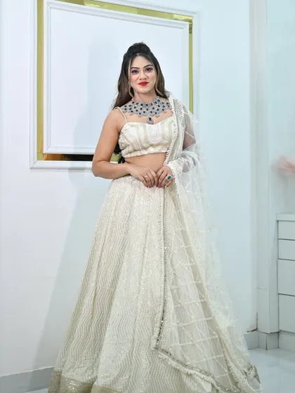 A full front view of the ivory chikankari lehenga, complete with a sheer embellished dupatta.