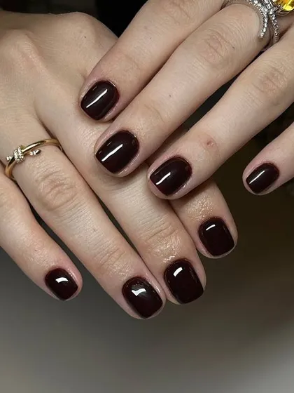 A deep, rich burgundy manicure perfect for the autumn season. The glossy finish on these short, square nails is impeccable.