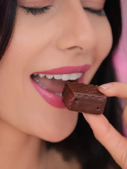 A close-up of the model enjoying the chocolate, focusing on the expression of delight. This shows how to direct models for lifestyle food photography.