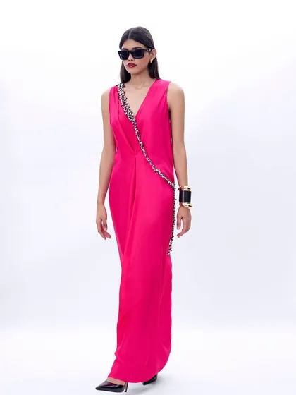A silhouette that whispers elegance. This fuchsia pink draped dress features an embellished strap, offering a modern and sophisticated look with a touch of glamour.