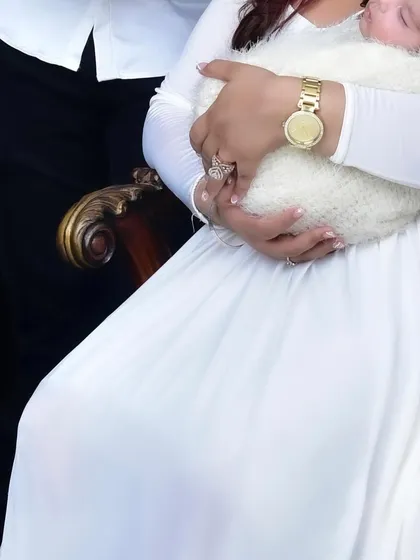 A close up shot focusing on a mother's hands securely holding her swaddled newborn baby. This image beautifully conveys the feeling of love and protection.