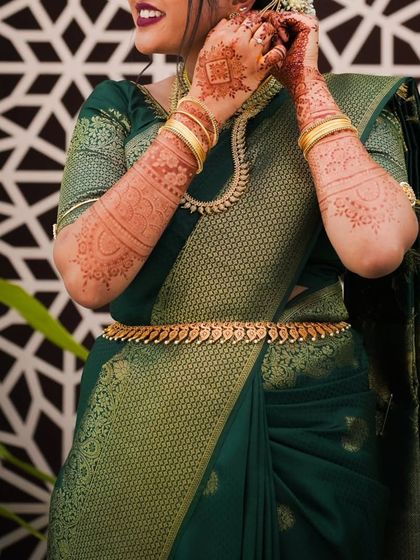 The henna stain looks stunning with this bride's green and gold silk saree.