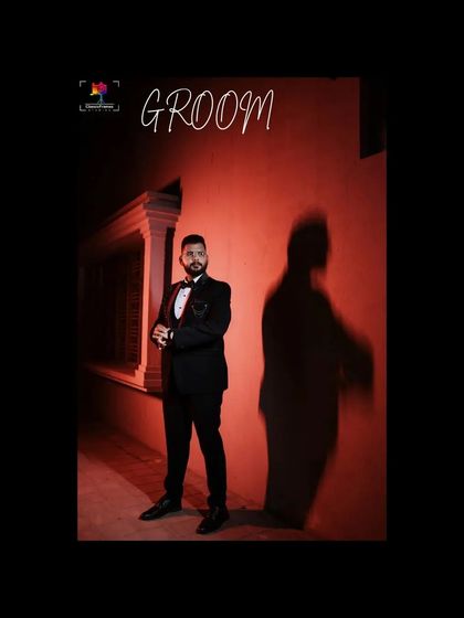 A dramatic groom portrait using a red background and shadow play. This artistic shot creates a bold, modern, and memorable image for his reception look.