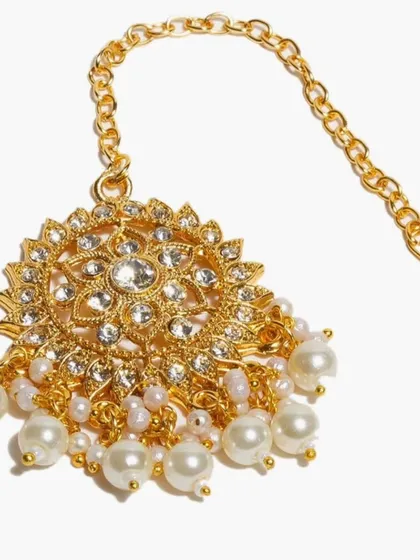 Sometimes, a single maang tika is all you need to complete your look. This delicate piece with kundan and hand-fixed pearls adds a touch of grace without being overwhelming. It is minimal, elegant, and rooted in tradition.