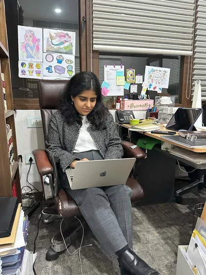 Focused at my desk, which is my command center. It might look messy, but it's an organized chaos of case files, research, and creative inspiration.