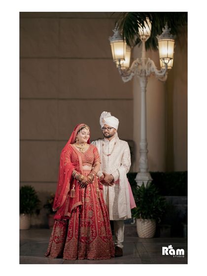 A classic full-length portrait of the couple outdoors at night. The elegant streetlamp and their regal attire create a timeless and sophisticated wedding photo.