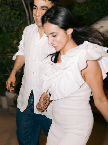 A candid shot of a couple running and laughing together, capturing their joyful and carefree spirit.