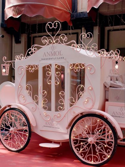A close-up of the beautiful pink carriage, adorned with fairy lights and intricate scrollwork.