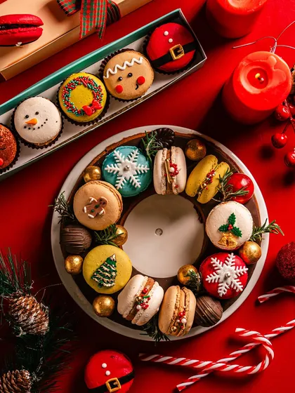 A festive macaron wreath and a box of Christmas-themed macarons, displayed on a vibrant red background. This image highlights my creative use of macarons, turning them into a beautiful and edible holiday decoration.