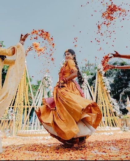 The pure joy of a Haldi ceremony! This candid shot captures the bride having fun with her friends, with flower petals being showered on her. Our decor provides the perfect, colorful backdrop for such happy moments.