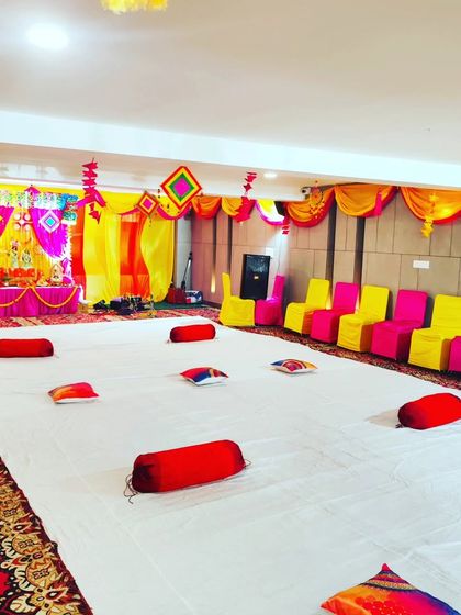 This image shows a flexible seating arrangement for a kirtan. I provide both traditional floor seating with bolsters on white sheets and chair seating along the sides to accommodate all guests comfortably.