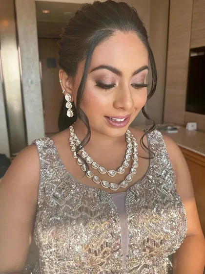 A beautiful candid shot showing the makeup with her eyes closed. The soft blend of eyeshadow and the flawless skin are on full display.
