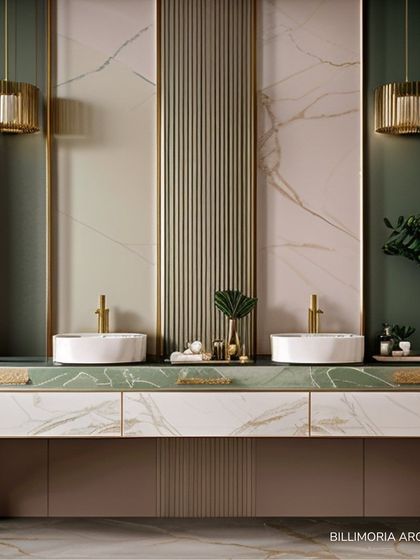 A double vanity design featuring a green marble countertop and vessel sinks. The wall combines fluted panels and soft pink marble, all framed with gold trim and elegant pendant lights for a sophisticated, art-deco feel.