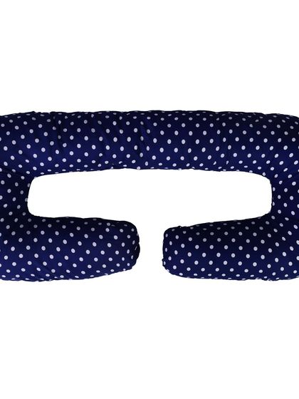 A C-shaped pregnancy pillow in navy with white polka dots, shot on a white background.