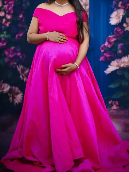This hot pink off-shoulder gown is a fantastic choice for a maternity shoot. The vibrant color and classic silhouette beautifully accentuate the baby bump.