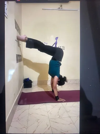 Here's a screenshot from an online class, showing how I use a strap and the wall to teach handstand alignment. This ensures my students practice safely and effectively.