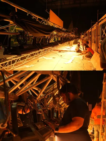 A behind-the-scenes look at the crew setting up the lighting for the Motorola train set. This shows the intricate work involved in rigging lights inside a confined space.