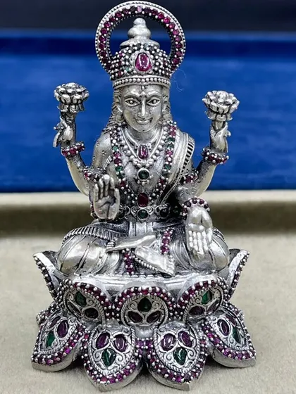 A close-up of our Goddess Lakshmi idol, seated on a lotus. Notice the detailed craftsmanship in her adornments and the clarity of the ruby and emerald stones, all set in 925 sterling silver.