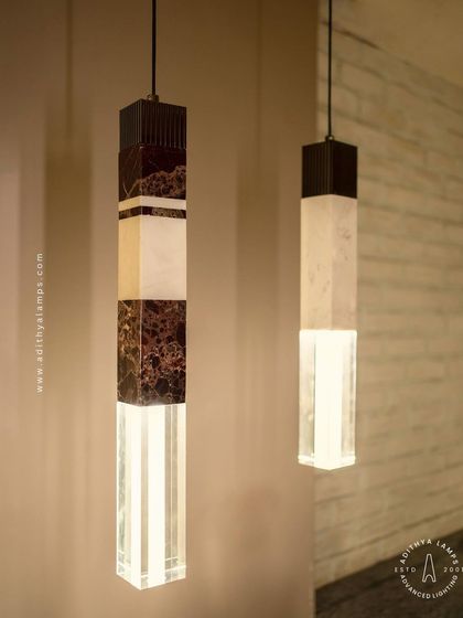 A collection of our pillar pendants, which combine sections of solid marble, fluted metal, and clear crystal. These substantial, high-quality fixtures can be hung individually or in clusters to create a dramatic effect in stairwells or entryways.
