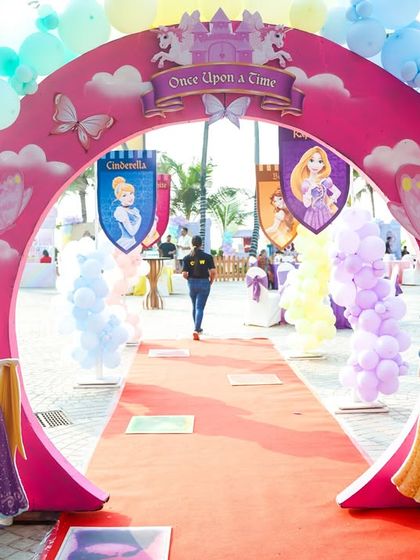A grand "Once Upon a Time" entrance arch for a princess party, complete with a red carpet and cutouts of Rapunzel and Snow White to welcome the royal guests.
