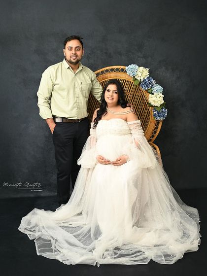 A classic seated portrait of the couple. The mom-to-be is framed by the peacock chair, adding a touch of boho elegance to the scene.