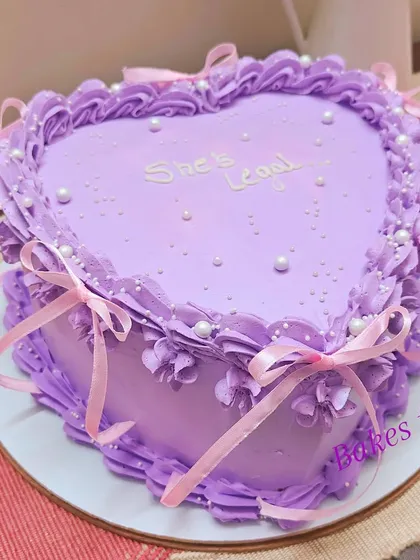 The same "She's Legal" 18th birthday cake, adorned with delicate pink ribbons for an extra pretty, coquette-style finish.