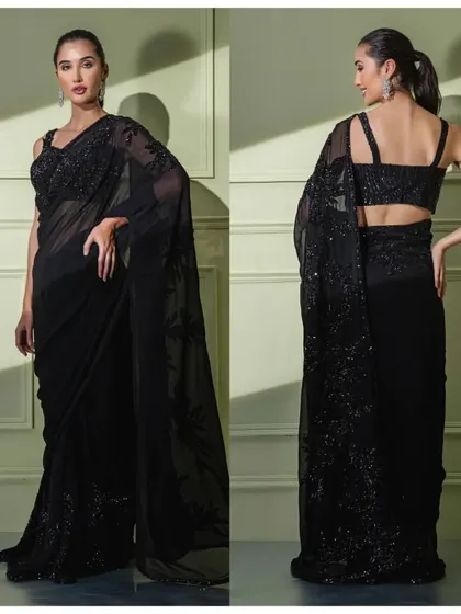 A timeless black georgette saree featuring delicate tonal floral embroidery. The strappy blouse adds a contemporary touch to this classic piece.