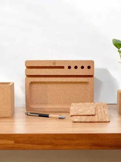 Organize your workspace sustainably with this cork desk set. It includes a pen stand, a tray, a card holder, and a planter, combining functionality with eco-friendly design.
