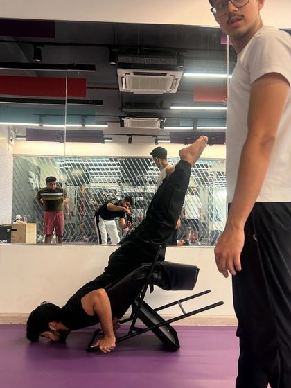 Another angle of a student working on a challenging arm balance with chair support. My role as a teacher is to provide the tools and guidance for you to grow.