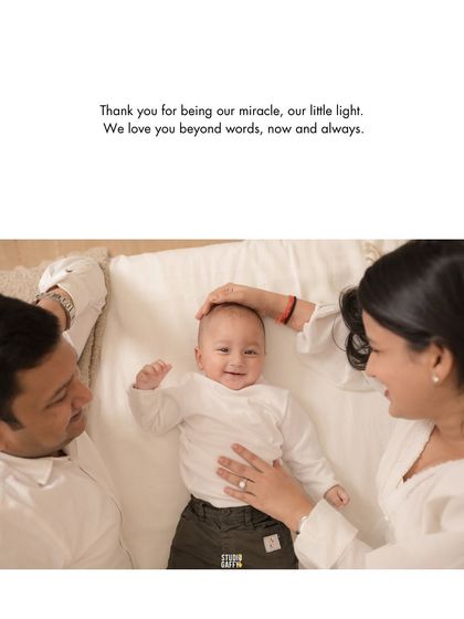 A beautiful overhead shot of new parents admiring their smiling baby. This image, with its simple white color palette, feels so pure and perfectly captures the miracle of new life.