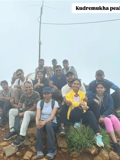 A group of trekkers at the Kudremukha peak summit marker, a proud moment after a long and beautiful hike.